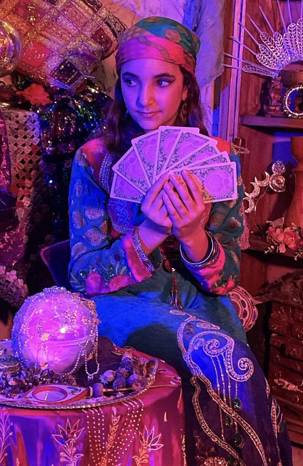 A fortune teller with tarot cards and a glowing crystal ball
